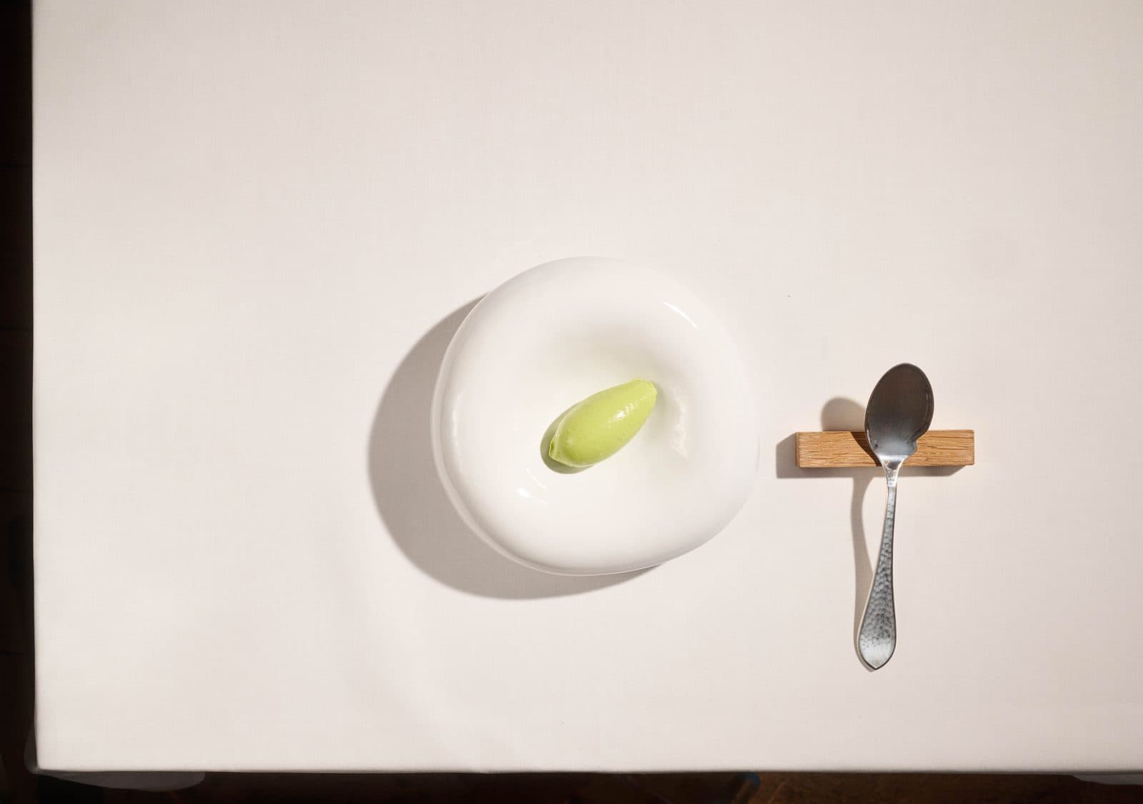 Grüne-Sauce-Eis-Quenelle am gedeckten Tisch